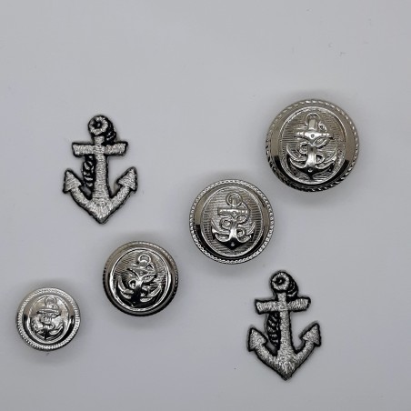 Botón decorativo con dibujo de ancla plateado metálico con pie. 