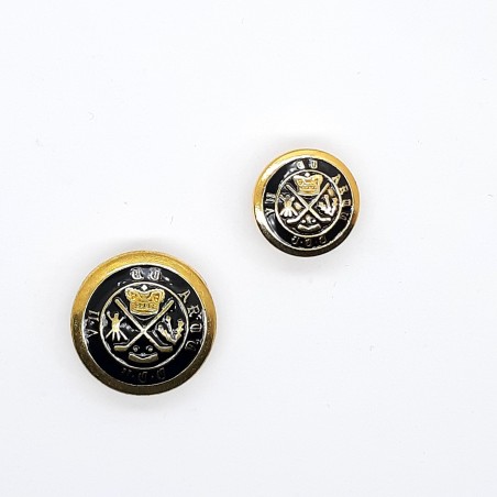 Botón clásico metálico con pie y escudo decorativo.