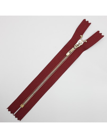 Cremallera metálica burdeos malla dorada.