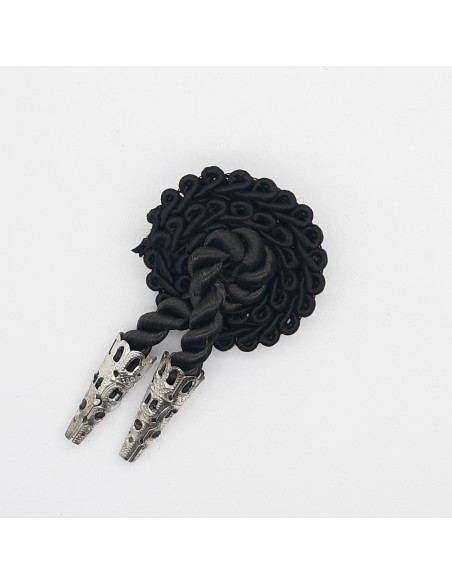 Alamar de pasamanería con cairel negro de seda y dos cabuzones plateados.